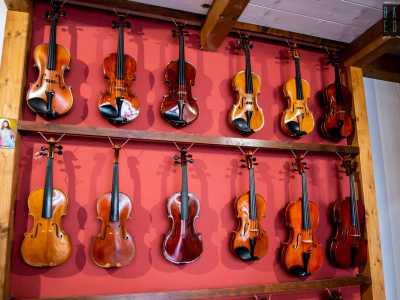Mentre su una parete rossa sono appoggiati degli splendidi esemplari di violoncelli, viole e violini, alcuni da resturare, altri pronti per essere venduti anche a migliaia di euro